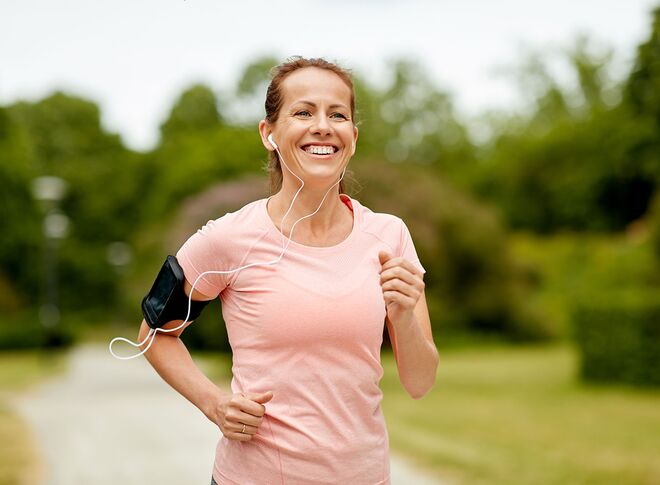 Sportliche Frau beim Joggen mit Kopfhörern